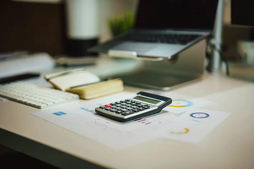 Calculadora y ordenador portátil para calcular el precio casa rural en Booking y Airbnb